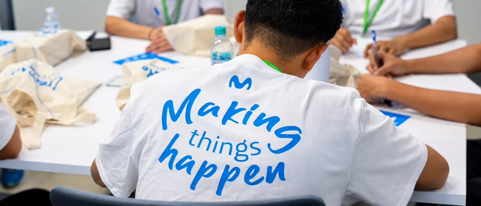 Jóvenes en una sesión de trabajo, con camiseta del programa «Making things happen» de Movistar