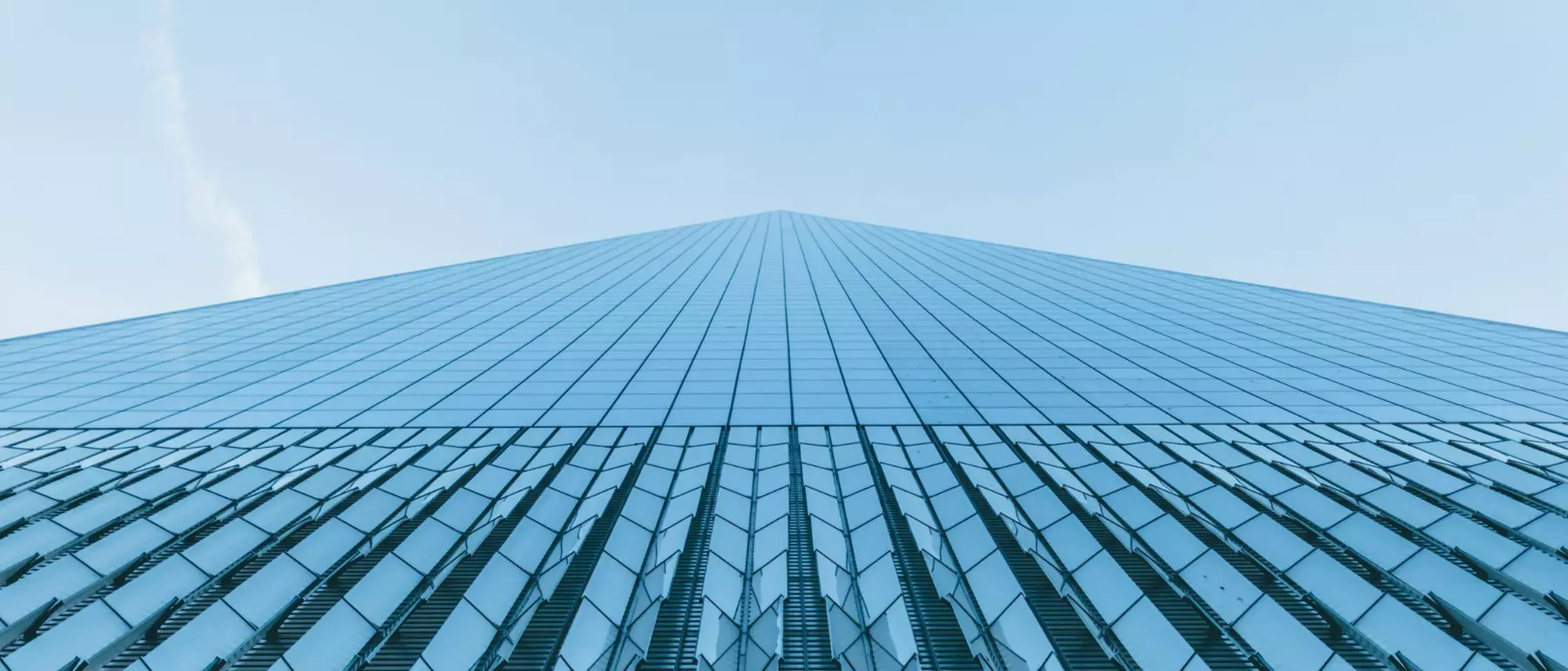 Fachada de vidrio de una torre corporativa vista en contrapicado