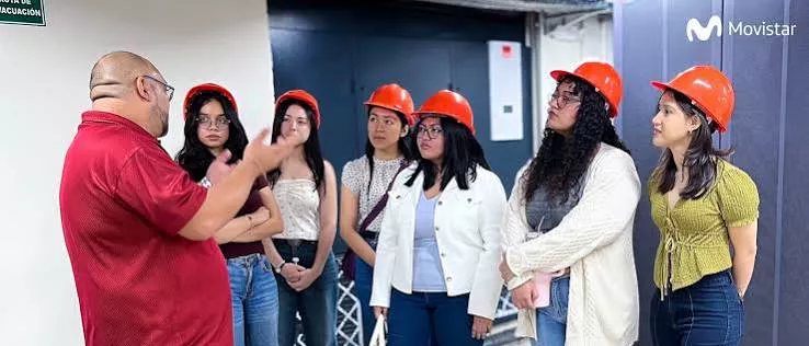 Grupo de estudiantes con casco de seguridad durante una visita técnica guiada en instalaciones de Movistar El Salvador