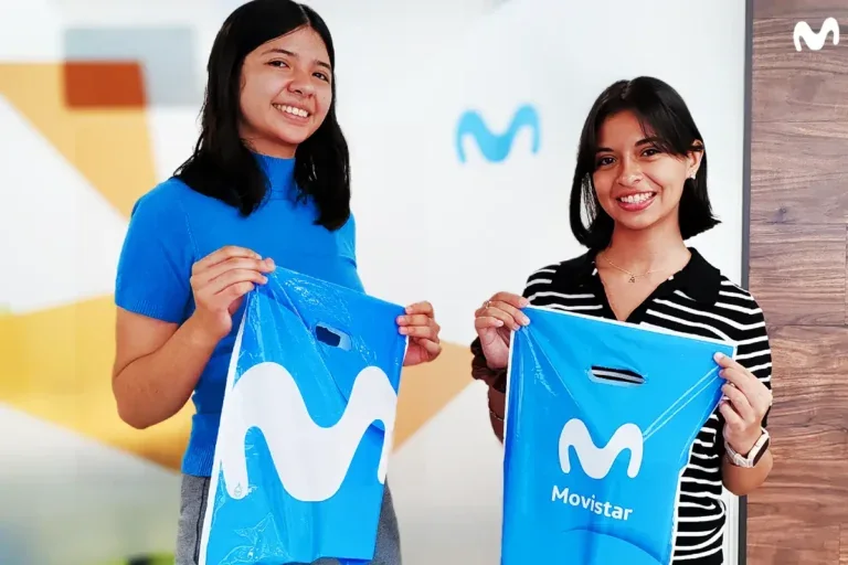Dos jóvenes sonríen con bolsas de Movistar